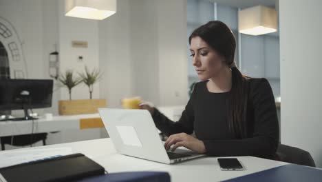 Eine-Frau-Arbeiten-am-computer-und-trinkt-Orangensaft