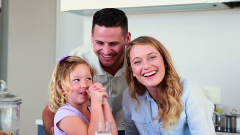 Little-girl-having-milk-and-cookies-with-her-parents