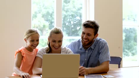 Una-familia-de-tres-está-usando-la-computadora-portátil