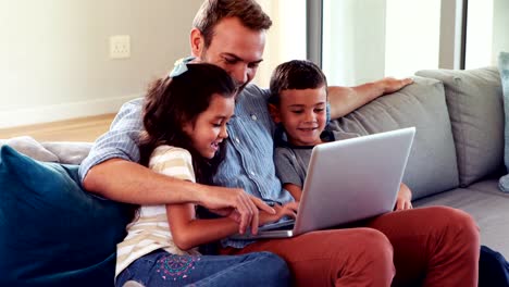 Glücklicher-Vater-mit-zwei-Kindern-mit-laptop