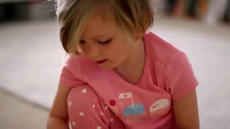 Little-girl-in-her-pajamas-putting-her-jewelry-in-her-jewelry-box,-slow-motion