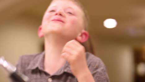 Young-boy-eating-ice-cream-and-raising-his-hand-and-smiling,-slow-motion