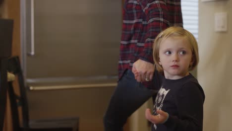 Mother-holding-her-daughter's-hand-and-walking-her-through-the-house