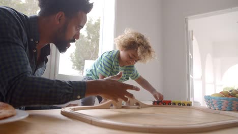 Padre-e-hijo-jugando-con-el-sistema-de-tren-de-juguete