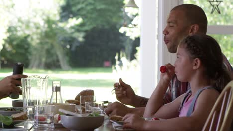 Familia-en-la-casa-comiendo-comida-en-comedor-juntos