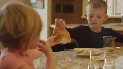 Bruder-und-Schwester-Teilen-Pfannkuchen-und-Essen-mit-den-Händen