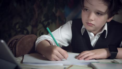 4K-tiro-alta-tecnología-de-un-niño-haciendo-la-tarea-y-comprobar-su-Tablet