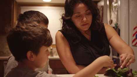 Two-boys-helping-their-mom-prepare-food-in-the-kitchen