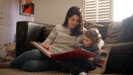 Mother-And-Daughter-At-Home-Looking-Through-Photo-Album