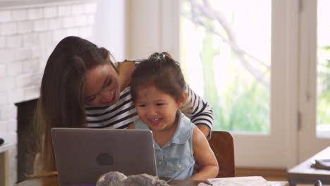 Madre-e-hija-ven-películas-en-la-computadora-portátil-en-casa-juntos