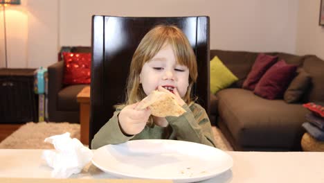 niño-pequeño-cantando-en-casa-y-comer-pizza