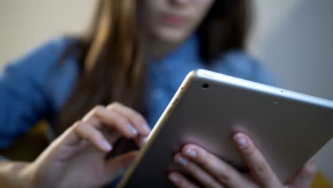 Woman-using-tablet-computer-touchscreen-in-cafe.-Close-up.