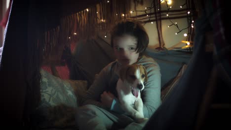 4k-Shot-of-Child-under-Blanket-Playing-with-his-Puppy-Pet