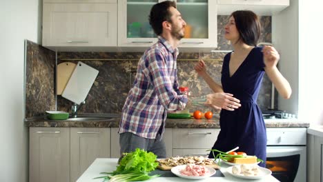 Glücklich-schönes-Paar-tanzen-und-küssen,-während-kochen-auf-der-Küche-zu-Hause