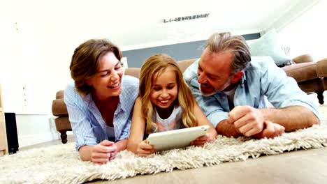 Familie-mit-Hilfe-von-digital-Tablette-im-Wohnzimmer