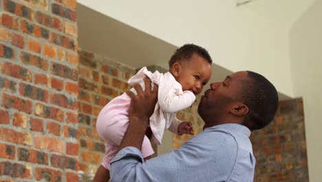 Father-Plays-Baby-Daughter-At-Home-As-Mother-Watches