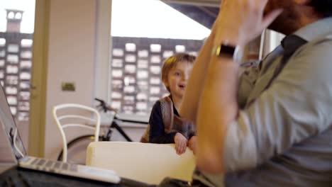 moderne-Familie-kleine-Mädchen-laufen-und-spielen-zu-Hause-mit-Papa-arbeiten-mit-Notebook.-Indoor-in-modernen-industriellen-Haus.-Kaukasische.-4-k-Handheld-Slow-Motion-video-sho