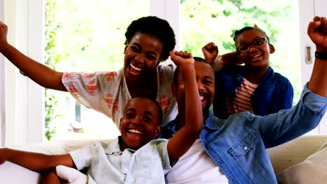 Parents-and-kids-having-fun-while-watching-television-in-living-room