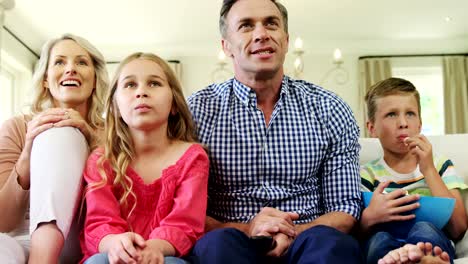 Familia-feliz-viendo-la-televisión-juntos-en-la-sala-de-estar