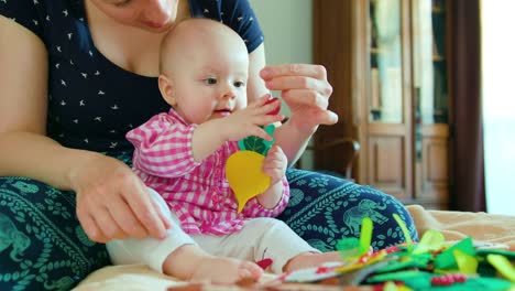 Baby-und-Mutter-und-mit-einem-Spielzeug-spielen