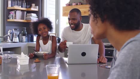 Family-Sitting-In-Kitchen-Enjoying-Morning-Breakfast-Together