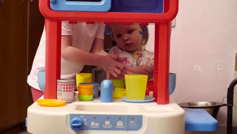 Two-sisters-playing-in-toy-kitchen