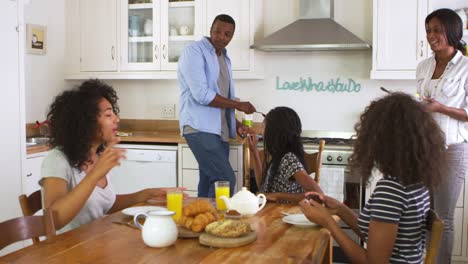 Familia-con-hijos-adolescentes-que-desayunan-en-la-cocina