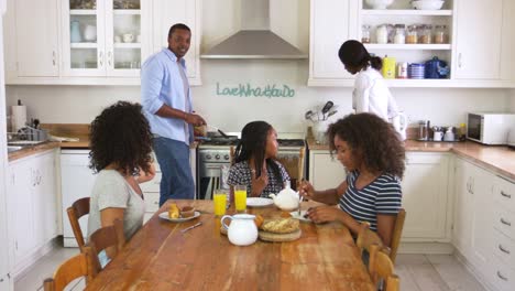 Familia-con-hijos-adolescentes-que-desayunan-en-la-cocina