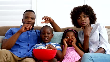 Familia-sentado-en-sofá-y-viendo-la-televisión