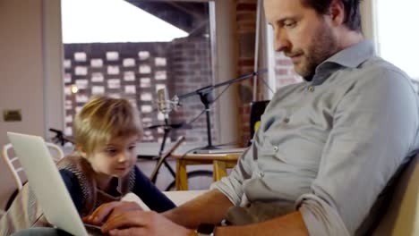 moderne-Familie-kleine-Mädchen-laufen-und-spielen-zu-Hause-mit-Papa-arbeiten-mit-Notebook.-Indoor-in-modernen-industriellen-Haus.-Kaukasische.-4-k-Handheld-Slow-Motion-video-sho