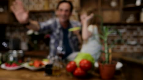 Hablando-de-hacer-Video-llamada-con-ordenador-portátil-de-cocina-durante-la-cocción-la-cena-en-casa-de-familia-feliz