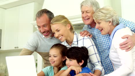 Familia-utilizando-laptop-juntos-en-la-cocina