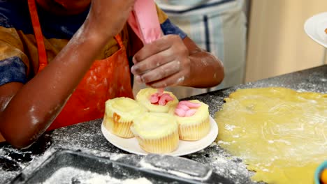 Mid-section-of-boy-preparing-cupcake-4k