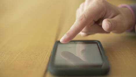 Lockdown-Shot-Of-Woman-Scrolling-Screen-On-Smartphone-At-Table