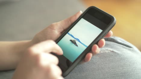 Closeup-Of-Woman-Browsing-Beach-Pictures-On-Smartphone