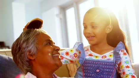 Granddaughter-brushing-her-grandmothers-hair-in-living-room-4k