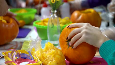 Concepto-de-las-relaciones-familiares.-Los-padres-y-los-niños-preparándose-para-la-celebración-de-Halloween.-Tallar-y-decorar-calabazas-juntos.-Calabaza-como-otoño-símbolo-de-Halloween,-acción-de-gracias,-fiestas-de-cosecha-y-calabaza-especia-latte