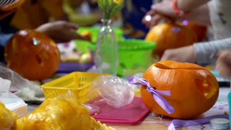 Concepto-de-las-relaciones-familiares.-Los-padres-y-los-niños-preparándose-para-la-celebración-de-Halloween.-Tallar-y-decorar-calabazas-juntos.-Calabaza-como-otoño-símbolo-de-Halloween,-acción-de-gracias,-fiestas-de-cosecha-y-calabaza-especia-latte