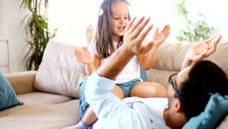 Portrait-of-father-and-daughter-playing-at-home