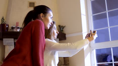 Dos-hermosas-amigas-hace-un-selfie-en-casa