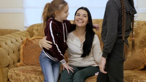 Two-little-daughters-gives-a-bouquet-of-flowers-to-their-mother