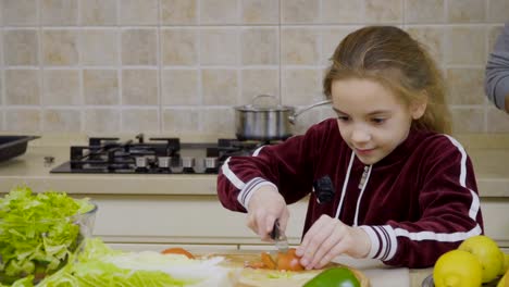 Kleines-Mädchen-lernt,-Tomate-schneiden