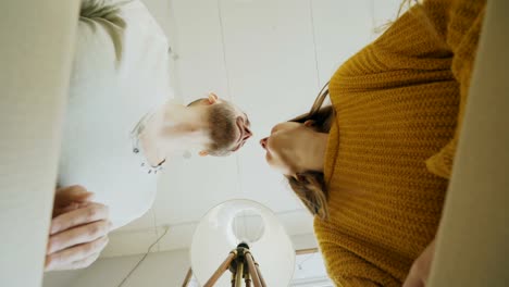 POV-of-happy-couple-kissing-while-opening-cardboard-box-after-relocation-and-looking-inside-and-taking-things-in-new-house