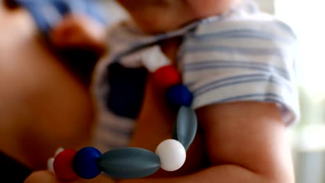 Cute-little-baby-carrying-pacifier-and-mother-holding-him-at-home-4k