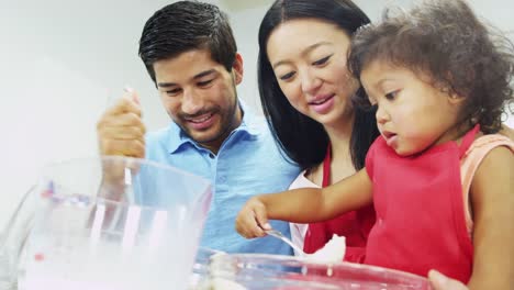 Little-Asian-girl-having-fun-baking-with-parents