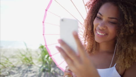 African-American-Frauen-mit-Smartphone-am-Strand