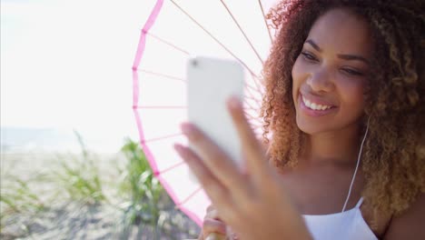 African-American-female-using-smart-phone-on-beach