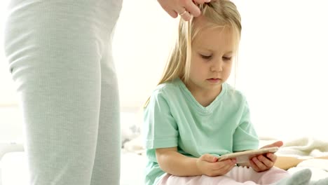 Mutter-Umsetzung-Töchter-Haare-in-Zöpfen.-Eine-glückliche-Familie.-Muttertag.-Frauentag