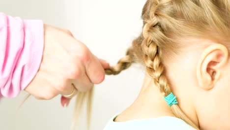 Mutter-Umsetzung-Töchter-Haare-in-Zöpfen.-Eine-glückliche-Familie.-Muttertag.-Frauentag