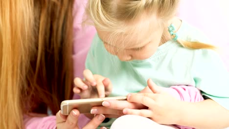 Feliz-joven-madre-e-hija-jugando,-dibujo,-juegos-en-el-teléfono-inteligente-trenza-trenzas,-leer.